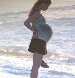  A pregnant Claire stands kwa the water in the Pilot